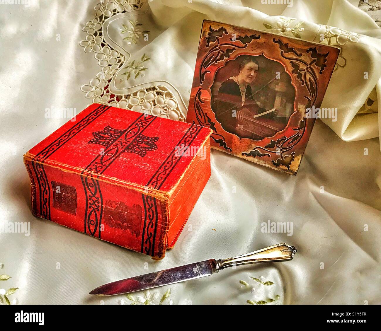 Still life antique arrangement of a silver photo frame, a silver letter opener and a book of Aristotle’s Works - Smartphone Captured Stock Image