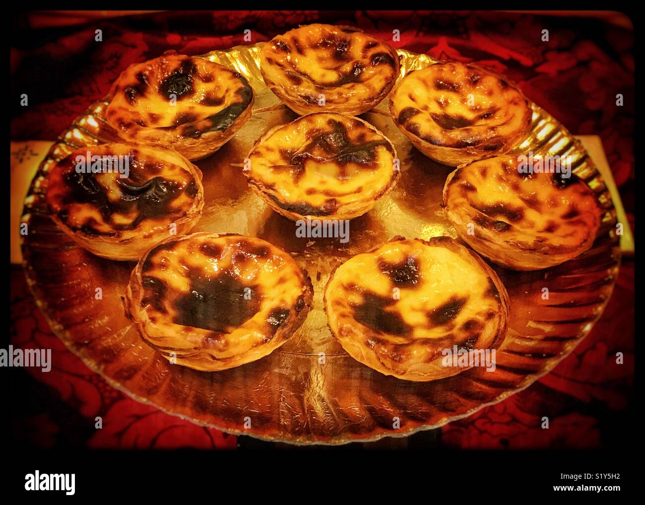A group of 8 tasty Nata custard tarts - an iconic cultural desert food from Portugal. These were found in the famous Pastéis de Belém in Lisbon. Photo Credit - © COLIN HOSKINS. - Smartphone Captured Stock Image