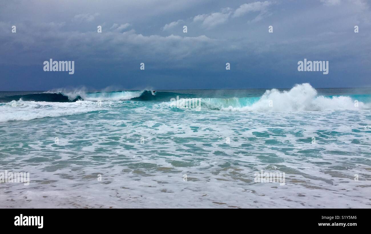 Surfers on big waves on the North Shore of Oahu, Hawaii on an overcast day. - Smartphone Captured Stock Image