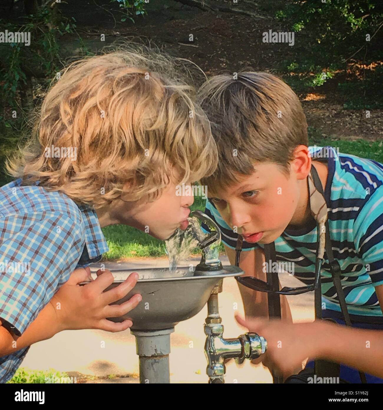 Children drinking from a water fountain Stock Photo