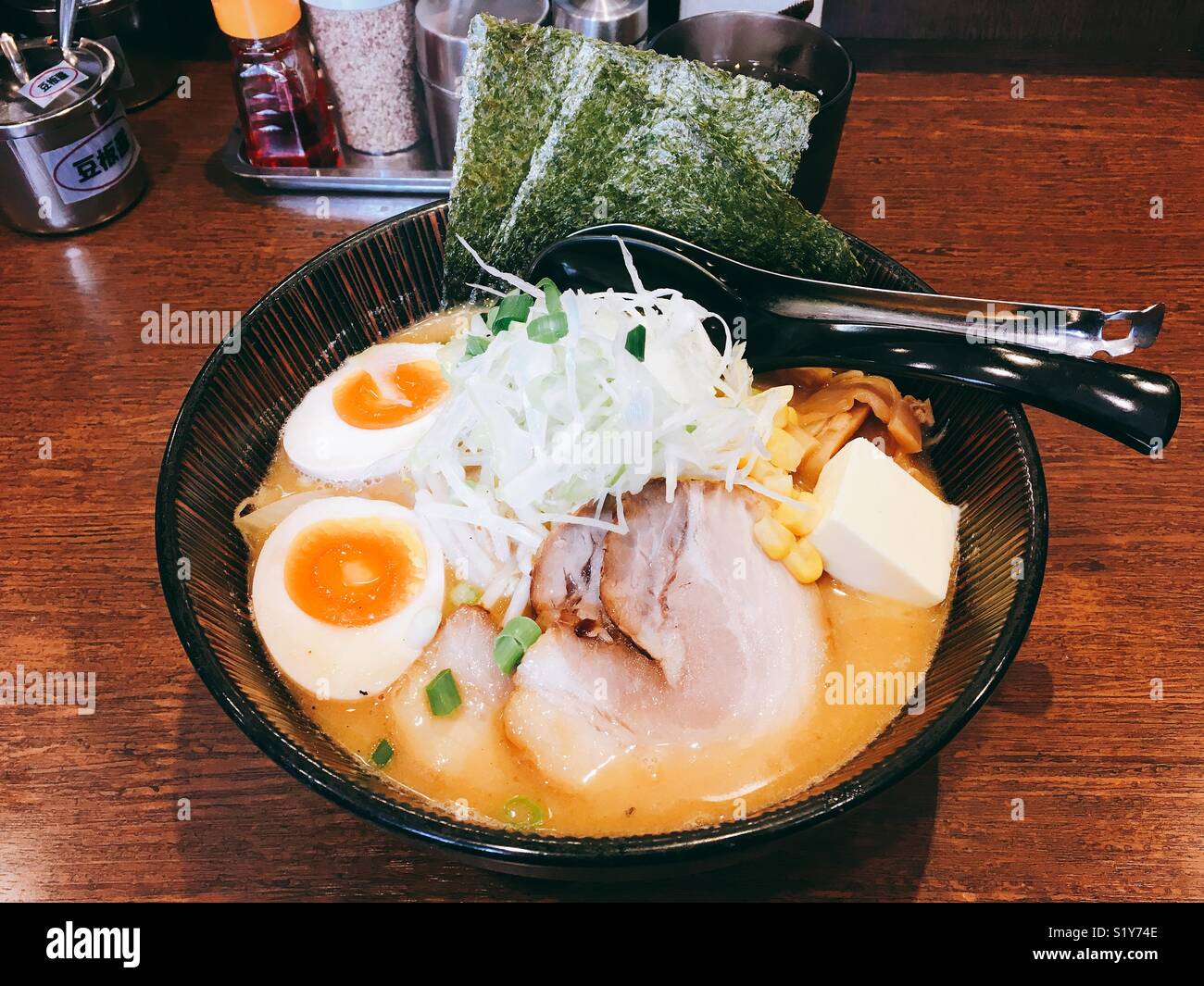 Delicious bowl of Japanese ramen. An extra spoon with holes in it was