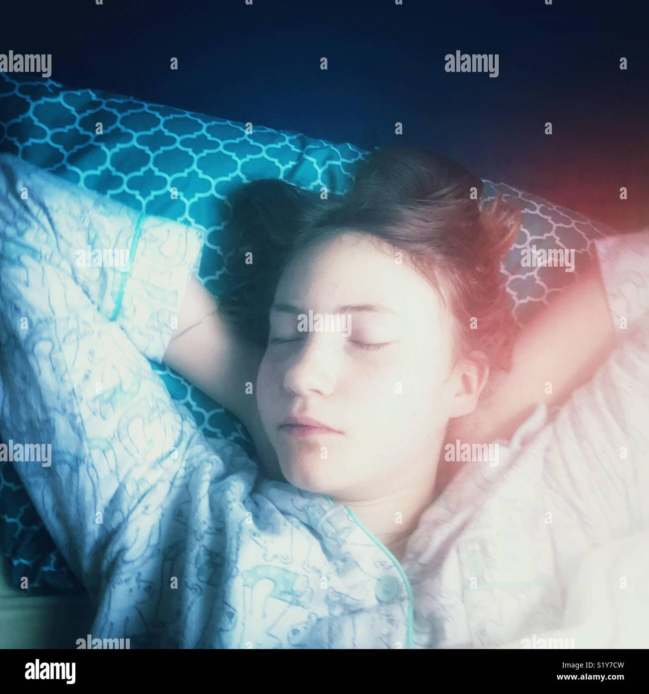 Sleeping adolescent girl with cool, dreamy lighting Stock Photo