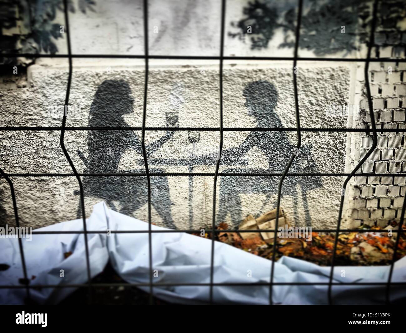 A silhouette of a couple drinking in a bar behind bars in Seville, Andalusia, Spain - Smartphone Captured Stock Image
