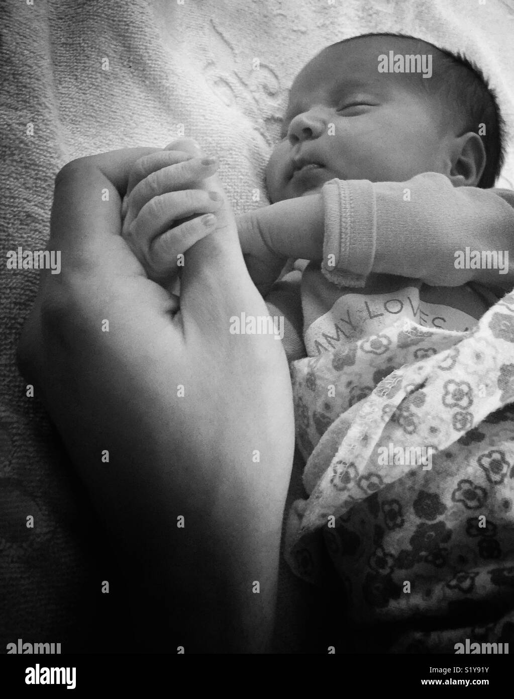 Baby sleeping holding daddys hand Stock Photo - Alamy