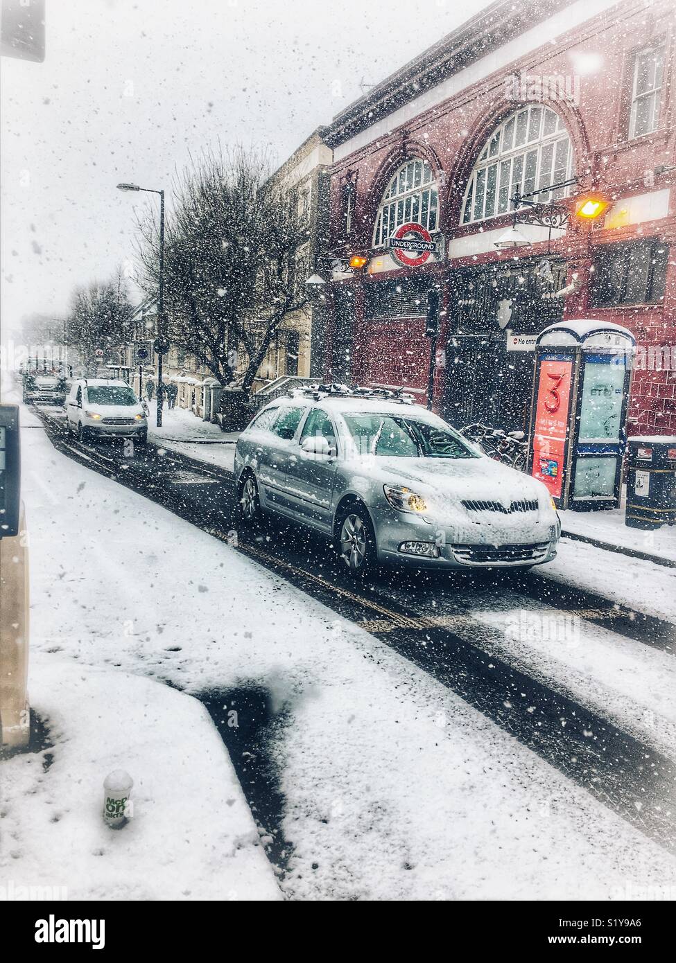 Street scene with traffic outside Tufnell Park station during heavy snowfall in London, N7 during the Beast From The East blizzard in March 2018. - Smartphone Captured Stock Image