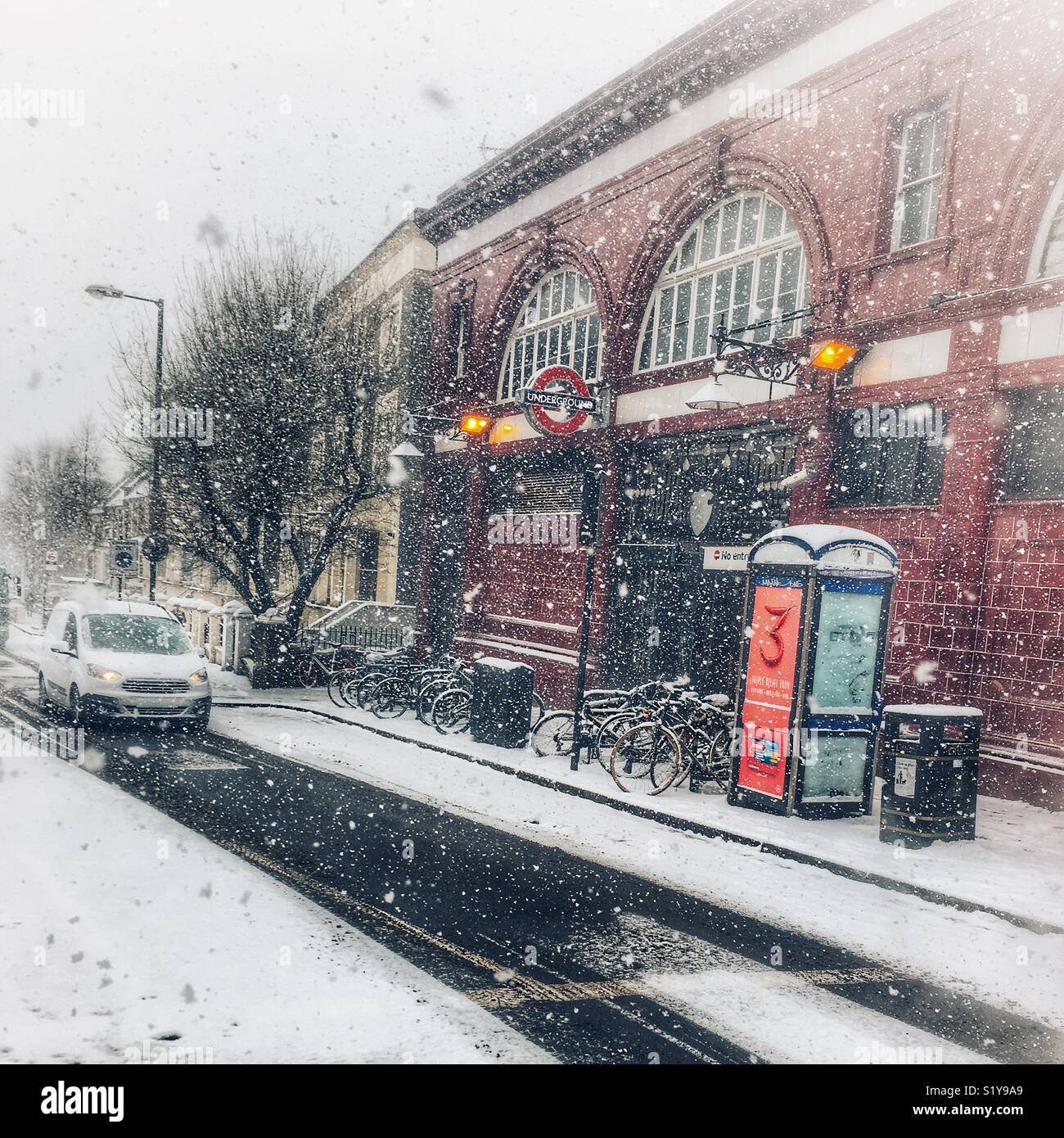 Street scene with traffic outside Tufnell Park station during heavy snowfall in London, N7 during the Beast From The East blizzard in March 2018. - Smartphone Captured Stock Image