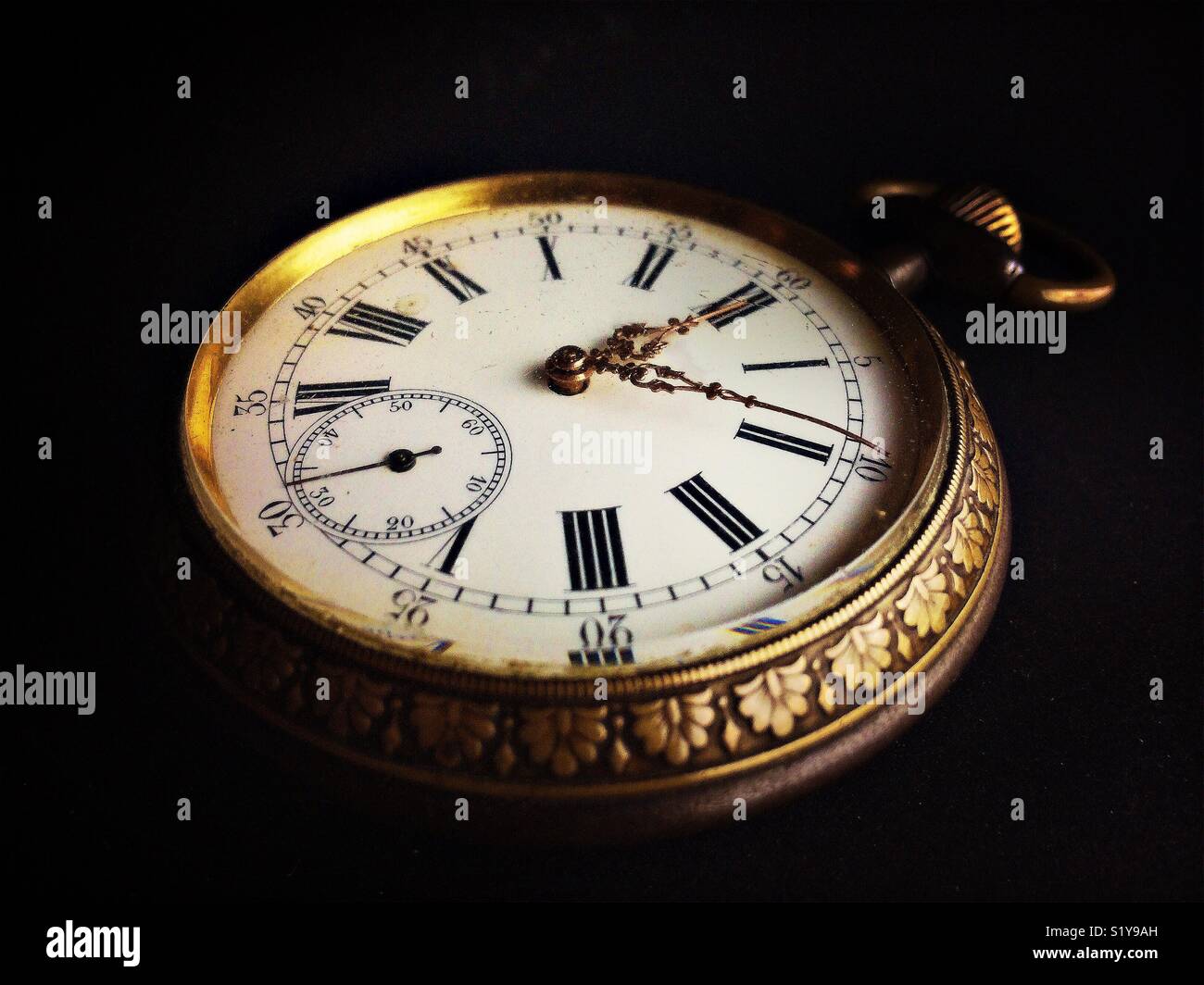 Close-up of an old golden watch isolated on a black background. - Smartphone Captured Stock Image