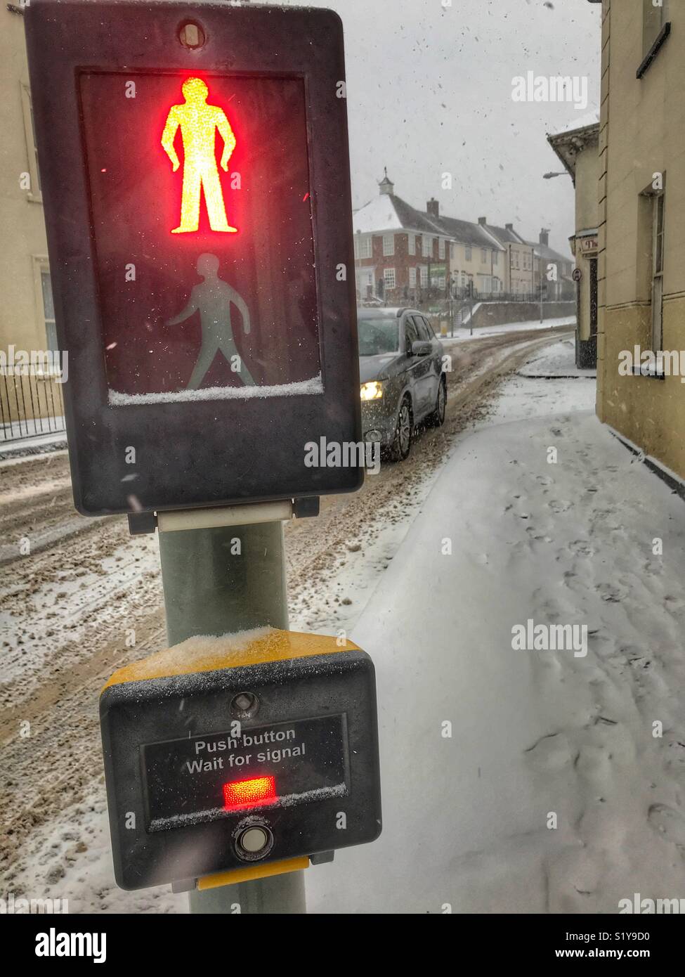 Pedestrian crossing, red light, with heavy snowfall in Sherborne, Dorset, England during the blizzard of Storm Emma, March 2018 - Smartphone Captured Stock Image