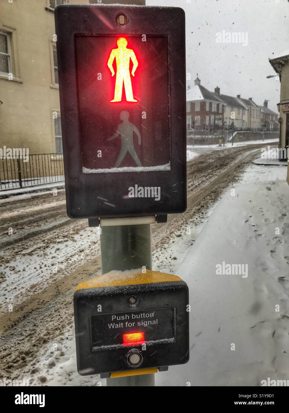 Pedestrian crossing, red light, with heavy snowfall in Sherborne, Dorset, England during the blizzard of Storm Emma, March 2018 - Smartphone Captured Stock Image