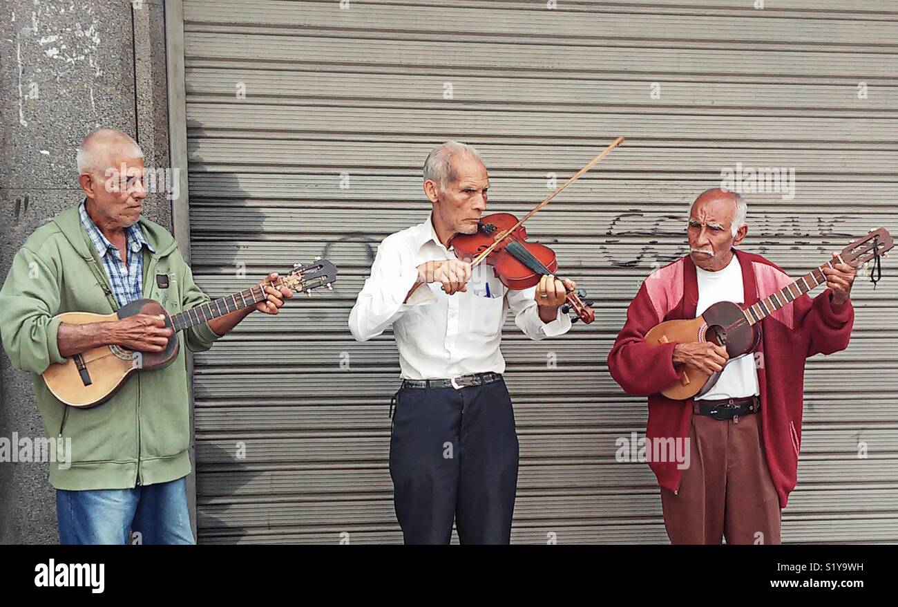 Senior citizens playing the violin and Cuatro in the street in Caracas. Street musicians. Active seniors - Smartphone Captured Stock Image