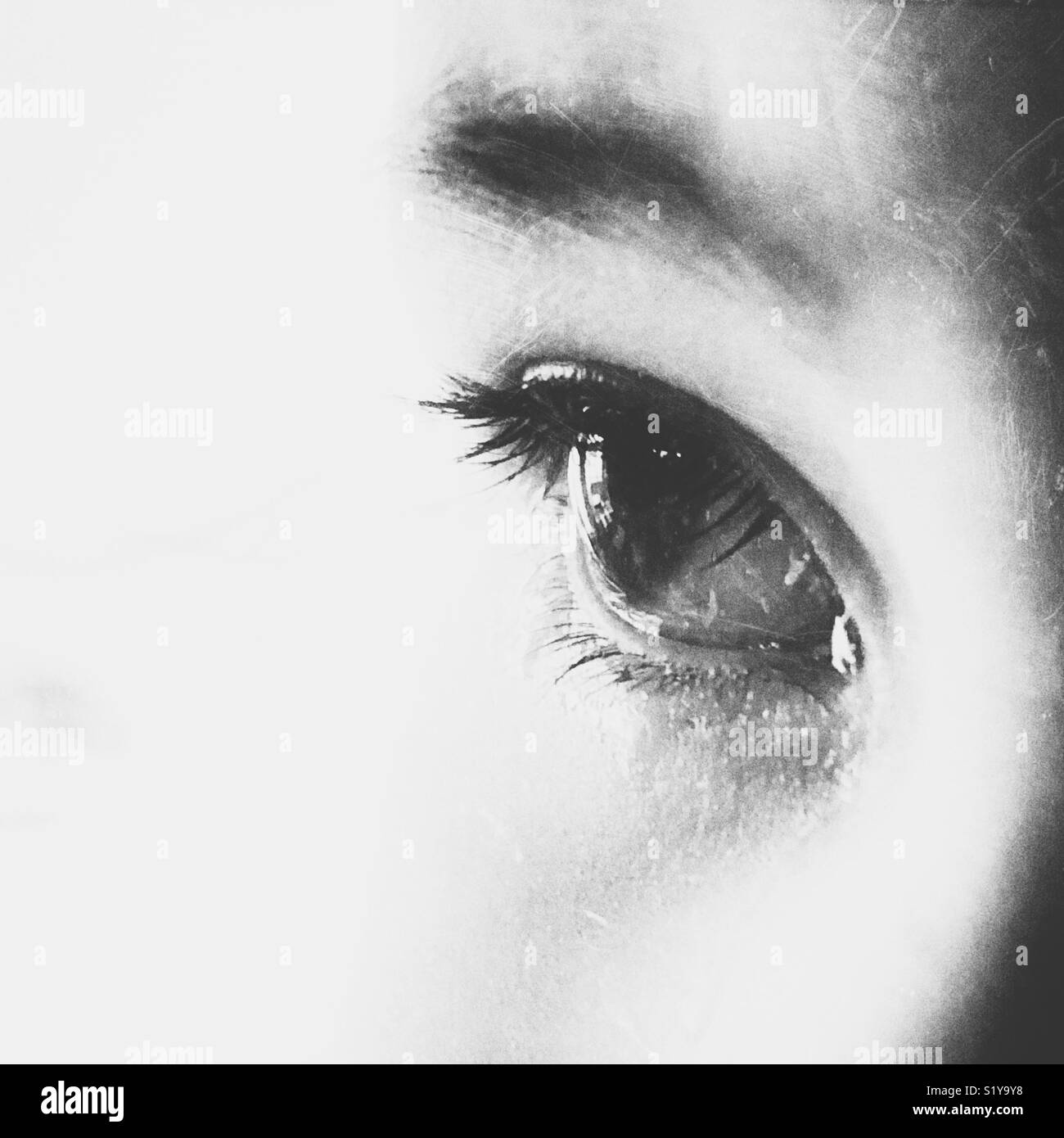 Black and white close up of teary child’s eye - Smartphone Captured Stock Image