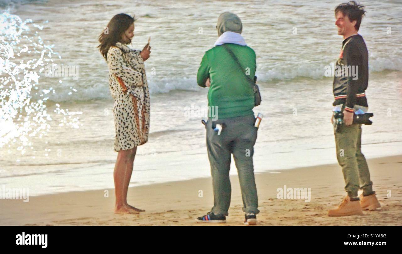 Hard work for Model , Stylist and Photographer on the beach. The Waves are rolling ... - Smartphone Captured Stock Image