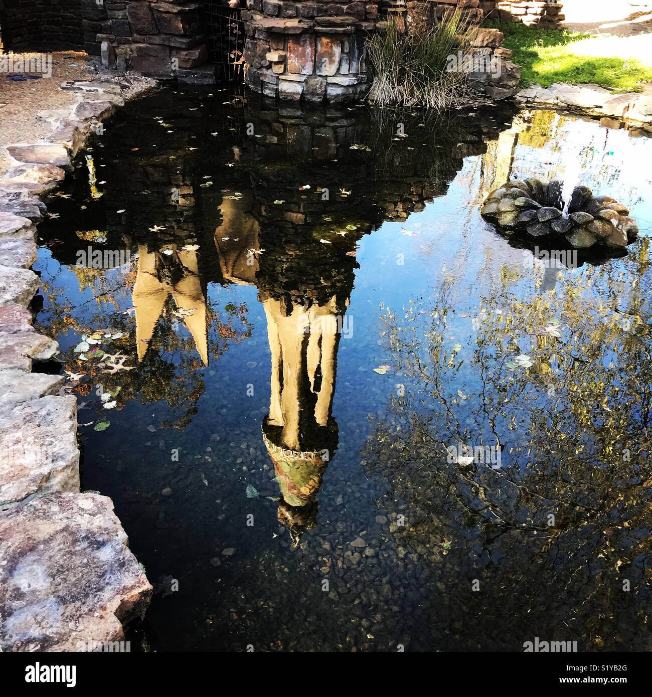 The castle at Wilson Park in Fayetteville, Arkansas is reflected in it’s own moat.  The moat is fed by a natural spring located beneath the castle. - Smartphone Captured Stock Image