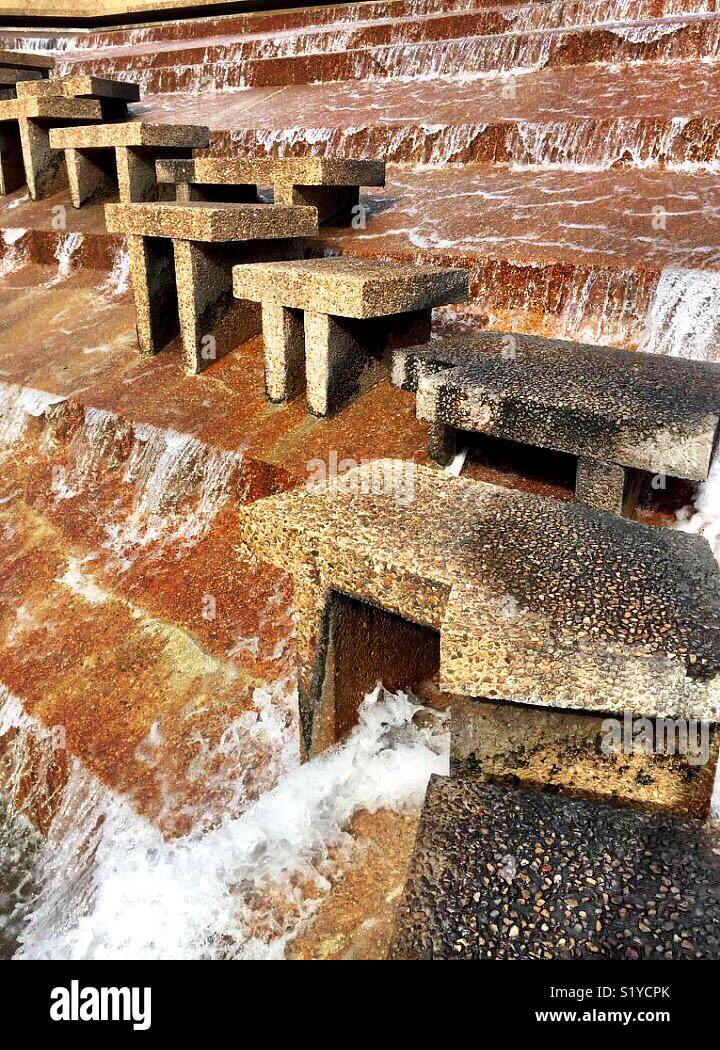 Water falls 38 feet over terraces into the eye of the active pool at the Fort Worth Water Gardens. The active pool has a path that allows visitors to experience the feel the heart of a cataract. - Smartphone Captured Stock Image