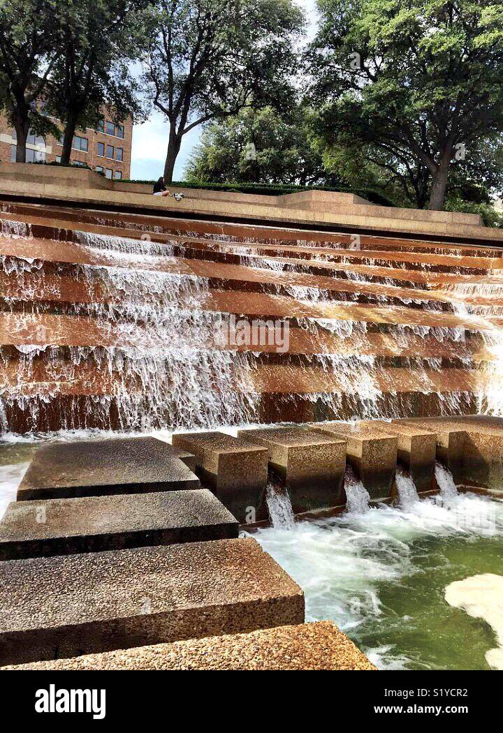 Water falls 38 feet over terraces into the eye of the active pool at the Fort Worth Water Gardens. The active pool has a path that allows visitors to experience the feel the heart of a cataract. - Smartphone Captured Stock Image