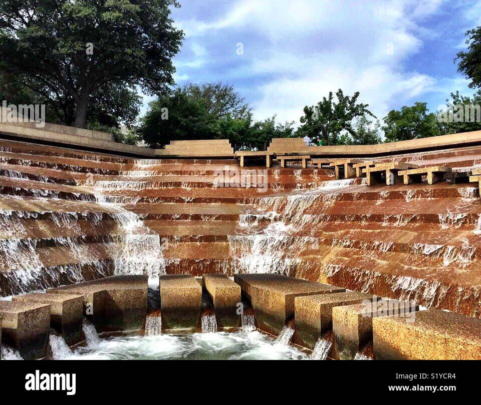 Water falls 38 feet over terraces into the eye of the active pool at the Fort Worth Water Gardens. The active pool has a path that allows visitors to experience the feel the heart of a cataract. - Smartphone Captured Stock Image