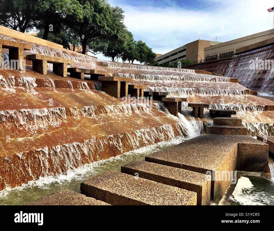 Water falls 38 feet over terraces into the eye of the active pool at the Fort Worth Water Gardens. The active pool has a path that allows visitors to experience the feel the heart of a cataract. - Smartphone Captured Stock Image