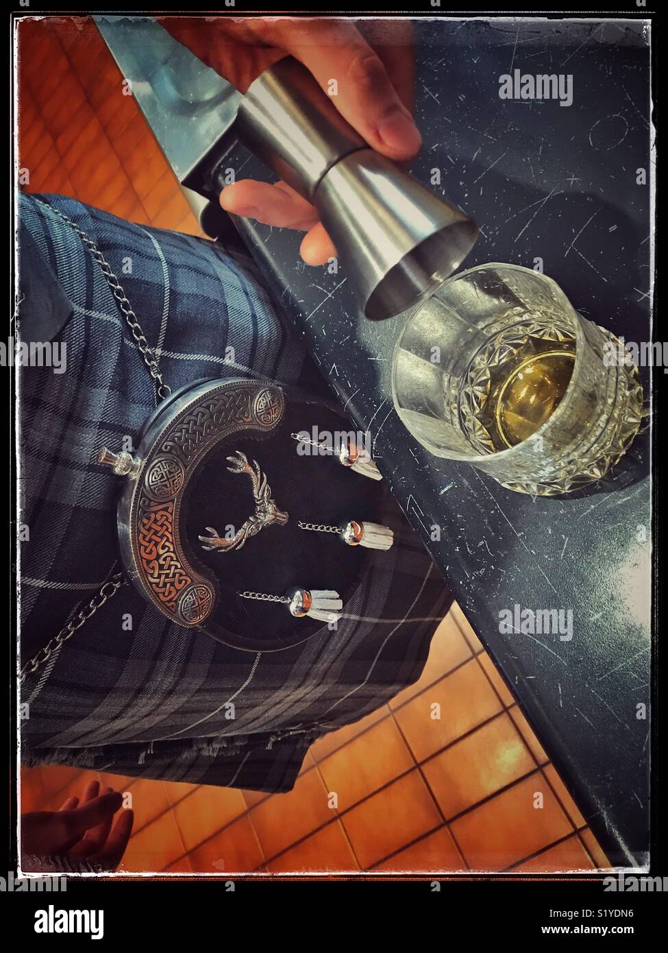 Man in kilt pouring a malt whiskey. - Smartphone Captured Stock Image