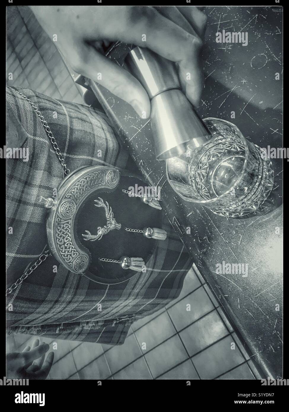 Man in kilt pouring a malt whiskey. - Smartphone Captured Stock Image