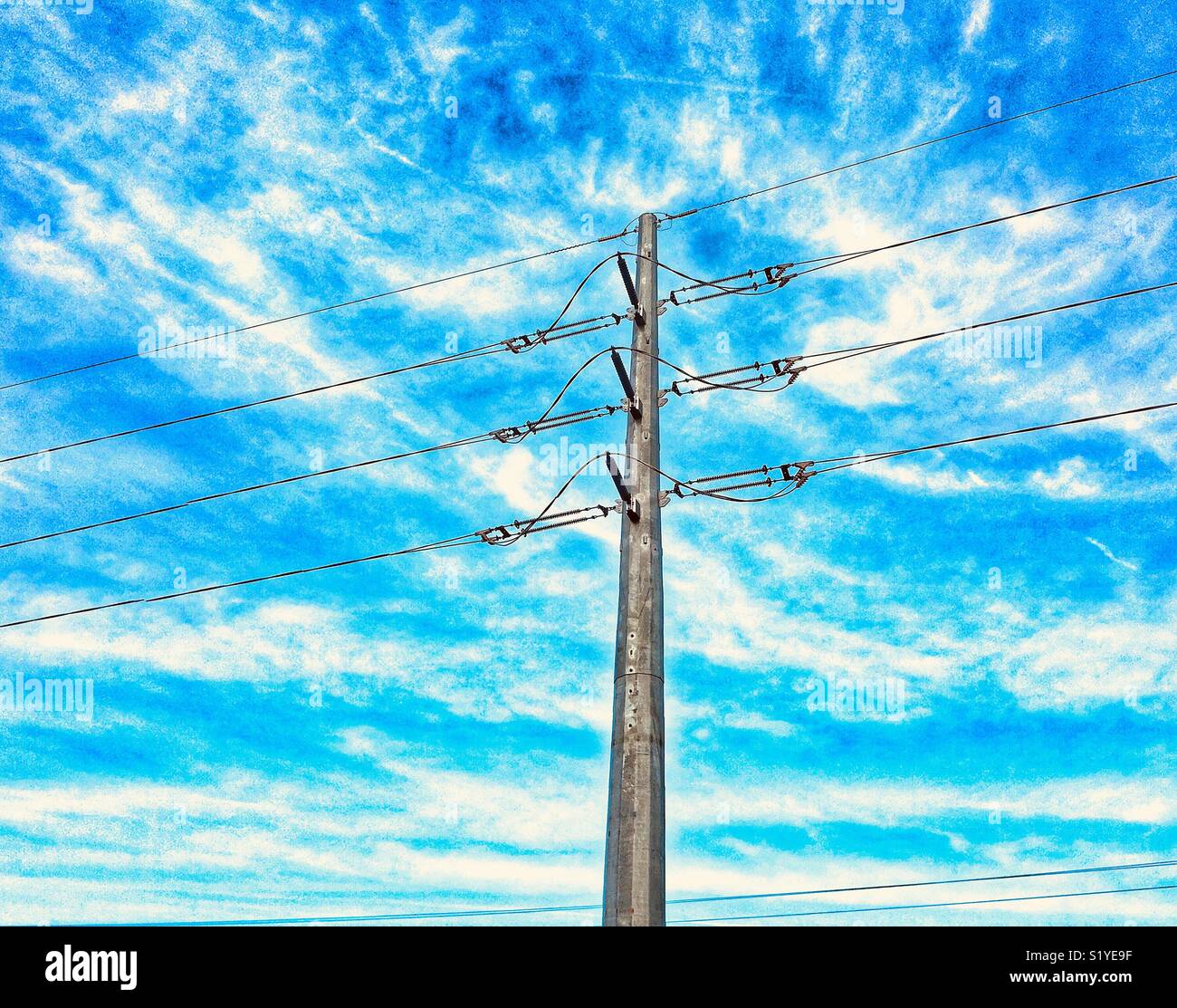Power lines against blue sky Stock Photo - Alamy