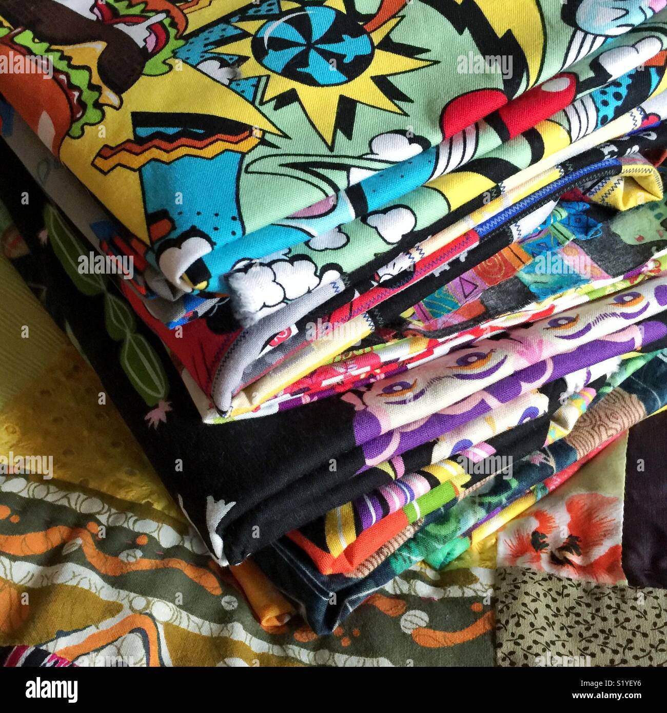 Stack of novelty fabrics on top of the quilt - Smartphone Captured Stock Image