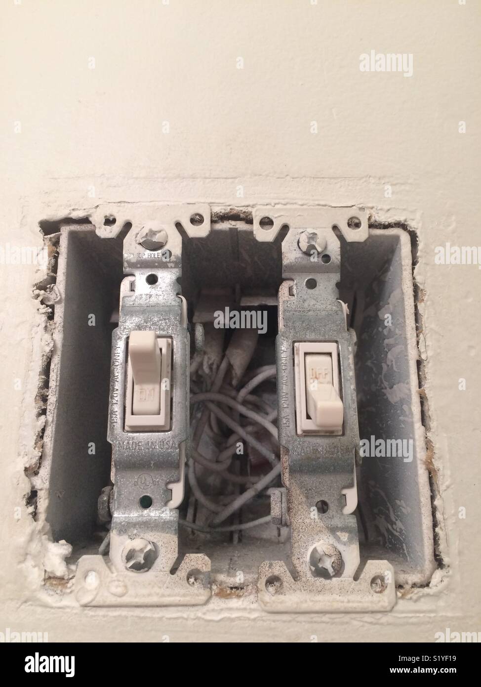 A bathroom light switch missing it’s plastic plate leaving exposed ...