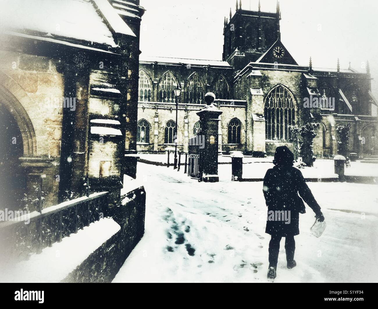UK, Weather, Sherborne, Dorset. Woman walking towards Sherborne Abbey in the historic market town of Sherborne as the so called mini Beast from the East brings another icy blast to the South West. - Smartphone Captured Stock Image