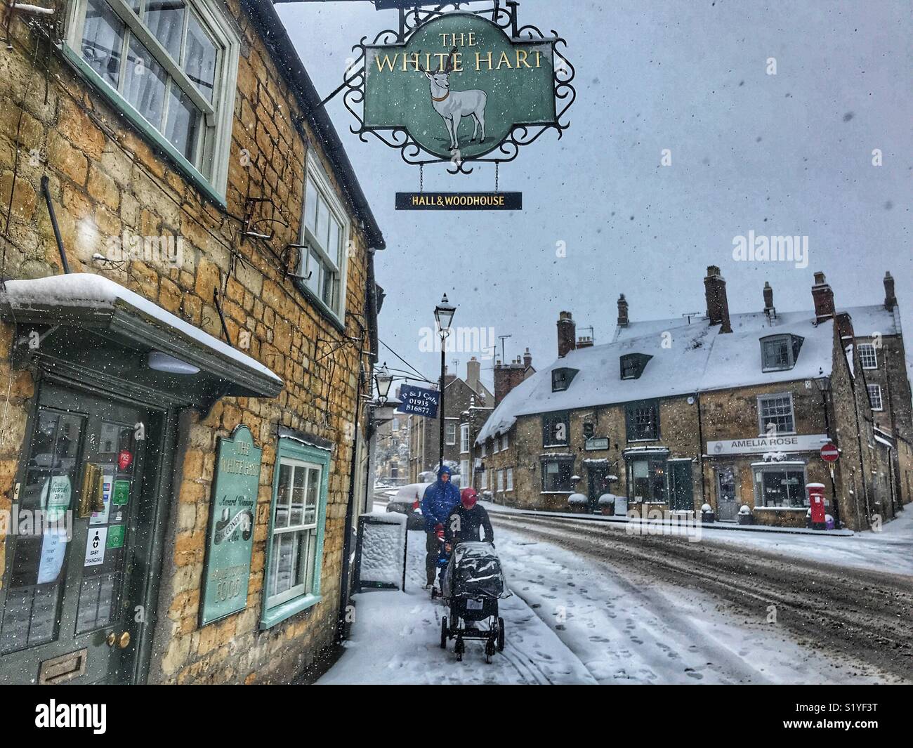 UK, Weather, Sherborne, Dorset. pushing a buggy through the snow in Sherborne as the so called mini Beast from the East brings another icy blast to the South West. - Smartphone Captured Stock Image