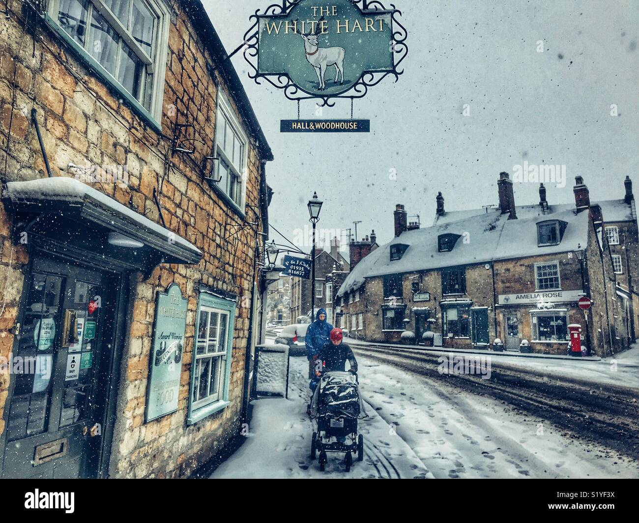 UK, Weather, Sherborne, Dorset. pushing a buggy through the snow in Sherborne as the so called mini Beast from the East brings another icy blast to the South West. - Smartphone Captured Stock Image