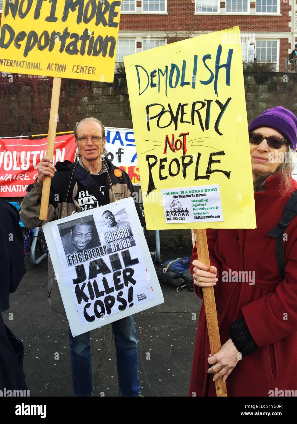 Middle aged man and woman holding protest signs during Dr..MLK JR. march in Seattle, WA Stock Photo