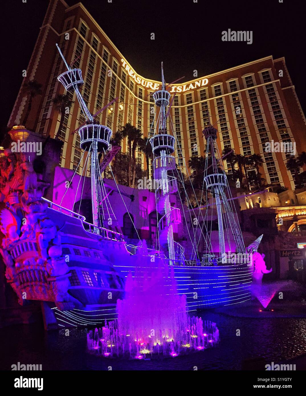 Pirate ship in front of Treasure Island hotel at night lit with neon lights in Las Vegas Stock Photo