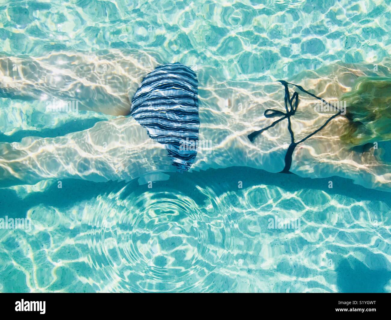 A women swimming underwater in a pool shot from above. Intercontinental hotel, Fiji. Stock Photo