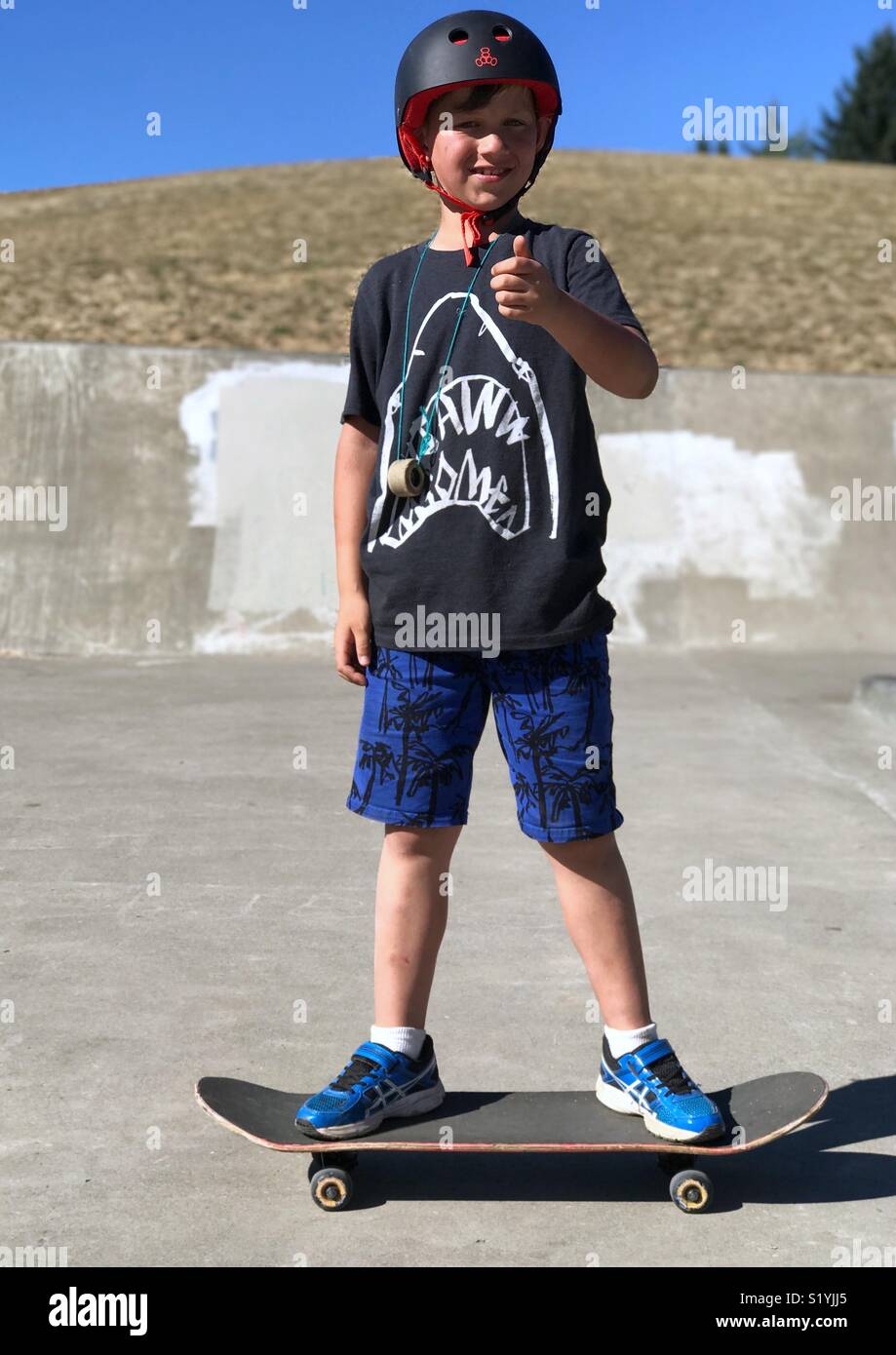 Boy on skateboard giving thumbs up Stock Photo Alamy