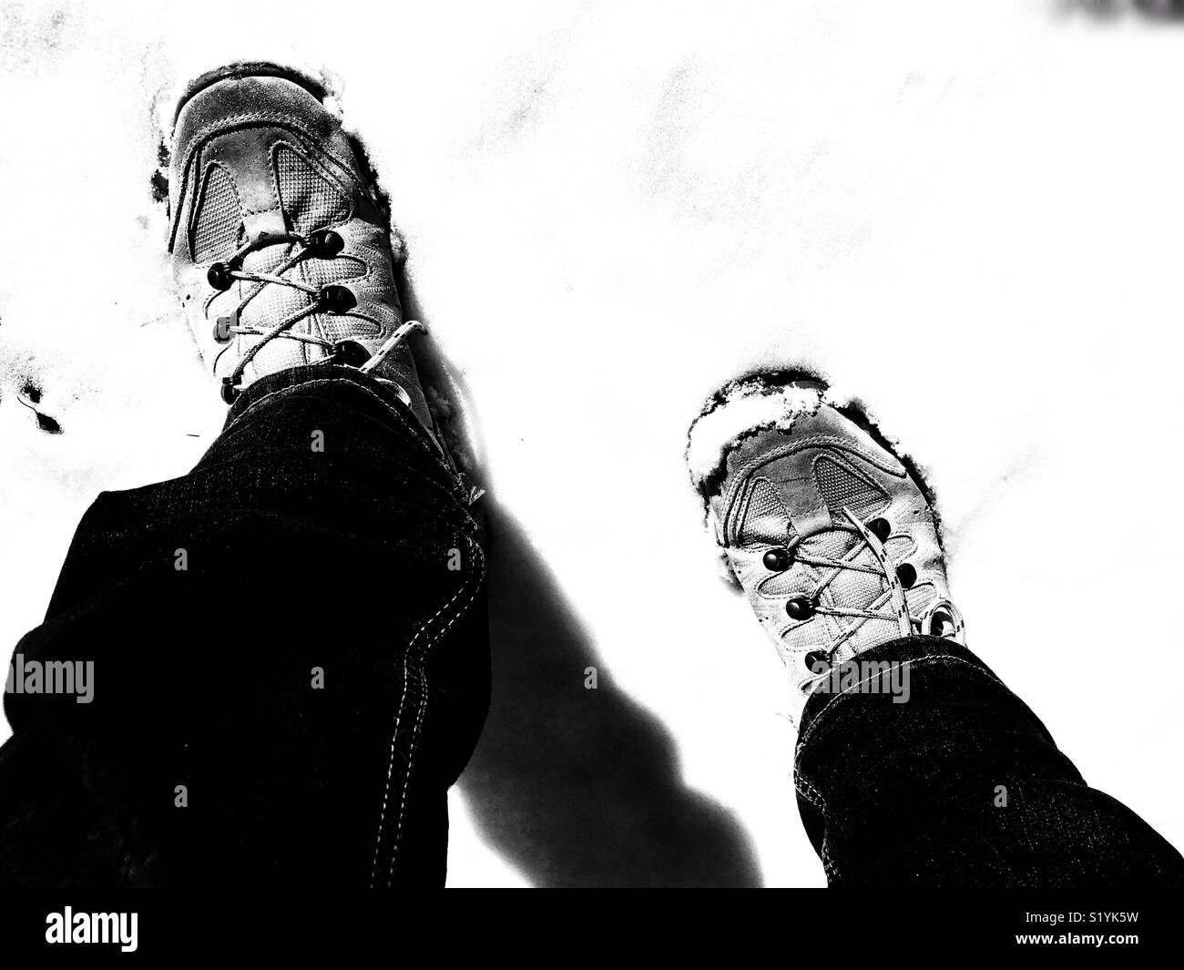 POV hiking boots in snow, high angle view, monochrome - Smartphone Captured Stock Image