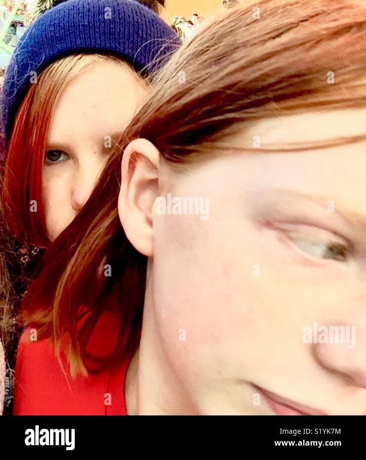Nonbinary, androgynous preteens or teenager faces with red hair, close up. Stock Photo