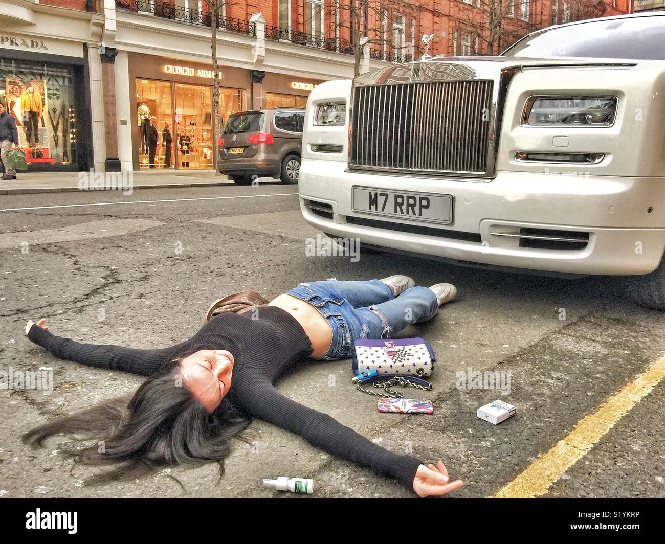 Model playing dead in Sloane Street, Knightsbridge London Stock Photo