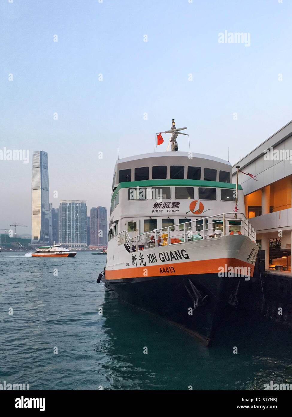 The ‘Xin Guang’, a triple-decker ferry operated by New World First Ferry Services between Central Piers on Hong Kong Island and the Outlying Island of Cheung Chau - Smartphone Captured Stock Image The ‘Xin Guang’, a triple-decker ferry operated by New World First Ferry Services between Central Piers on Hong Kong Island and the Outlying Island of Cheung Chau - Smartphone Captured Stock Image