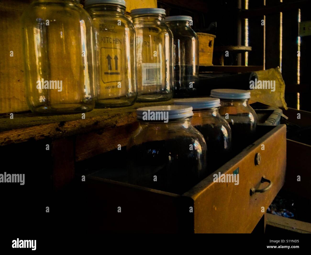 Large jars stored in old workbench in shed - Smartphone Captured Stock Image