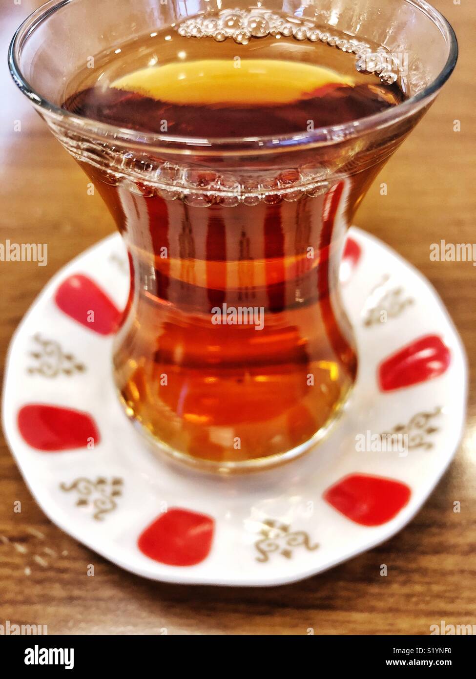 a glass of turkish tea on a wooden table Stock Photo