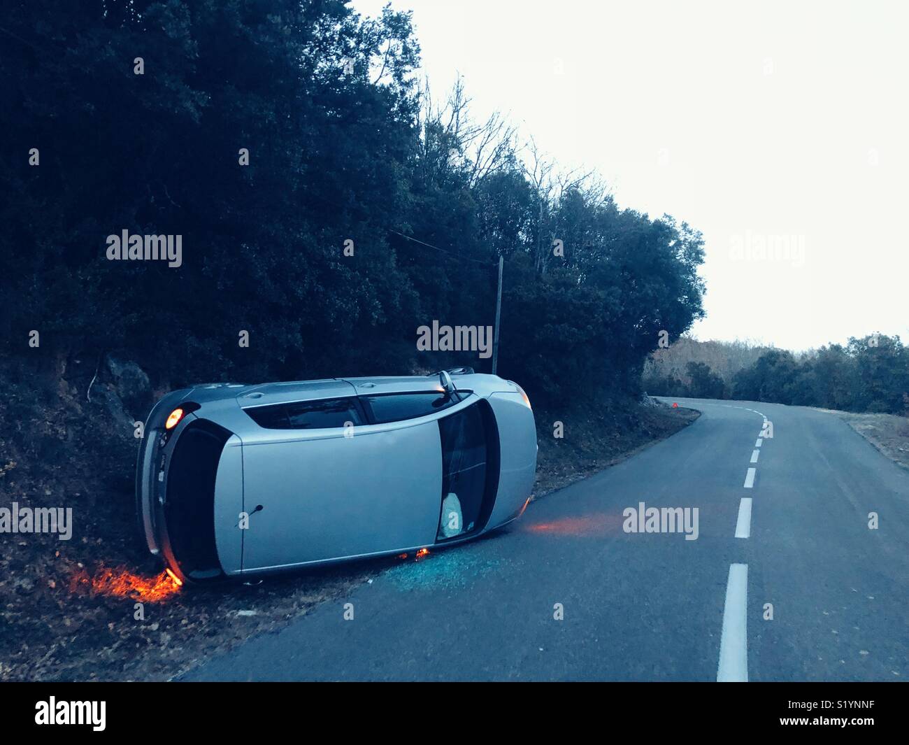 Upturned car on the road Stock Photo