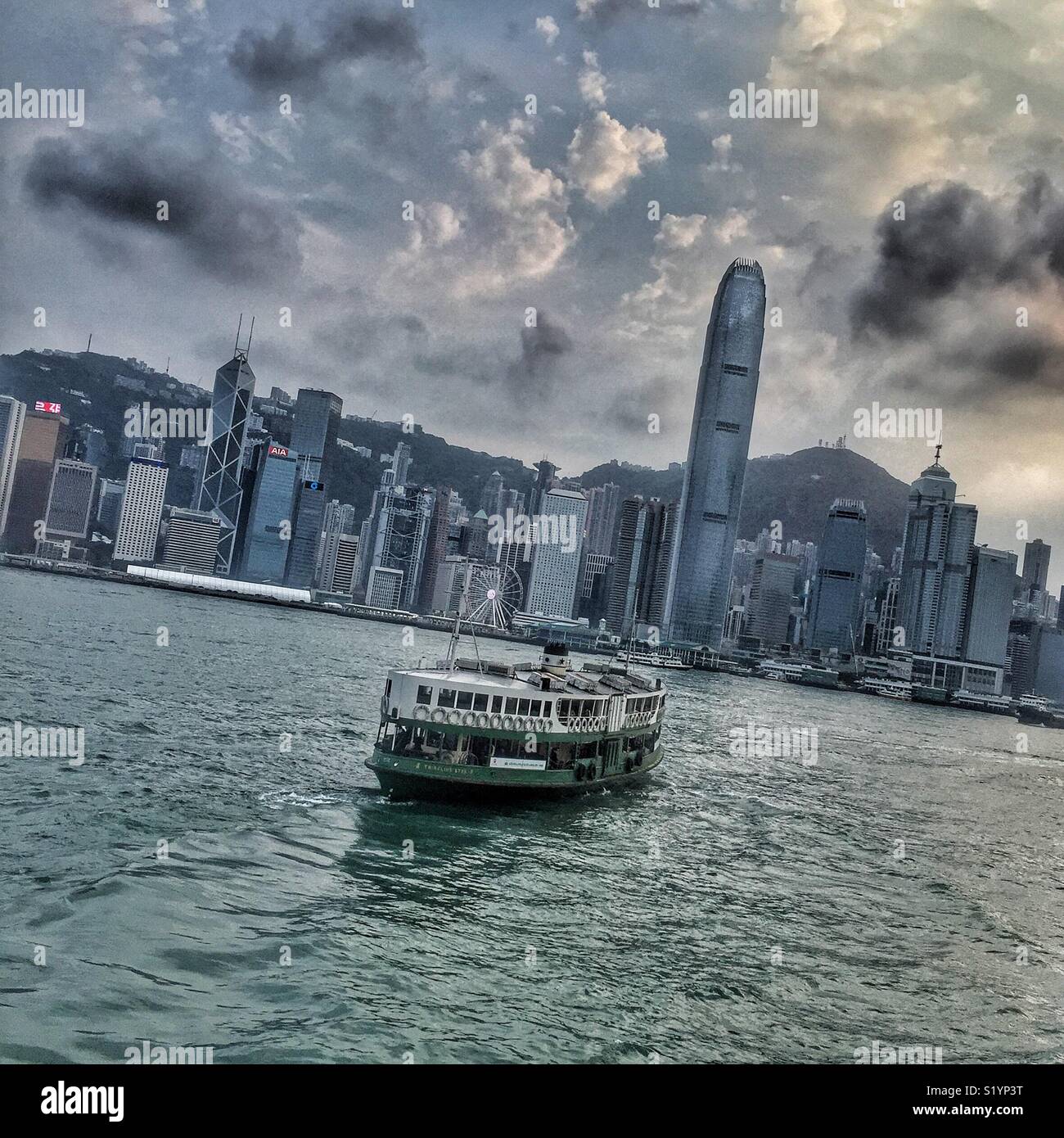 A Star Ferry leaves the pier at Tsim Sha Tsui, Kowloon, to cross Victoria Harbour to Central on Hong Kong Island - Smartphone Captured Stock Image