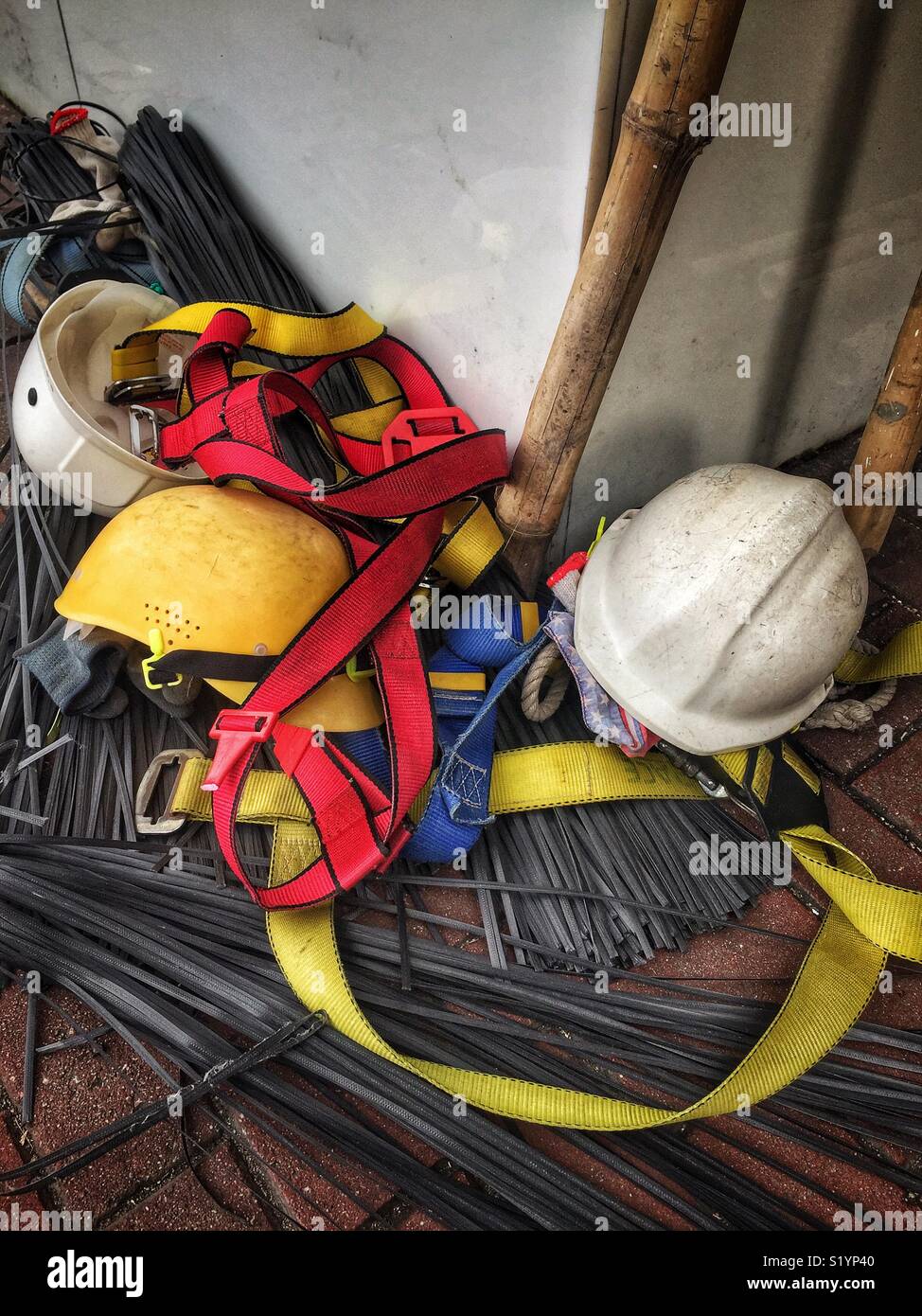 Safety helmets, harnesses and plastic ties used to construct bamboo scaffolding, Wan Chai, Hong Kong Island - Smartphone Captured Stock Image