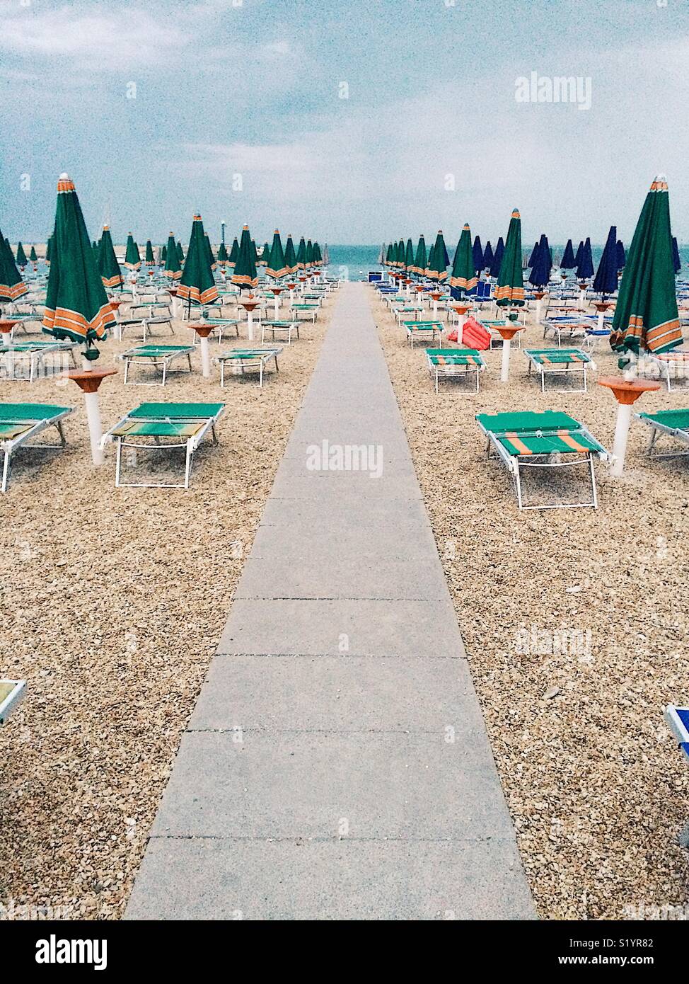 Lines of closed umbrellas on the beach - Smartphone Captured Stock Image