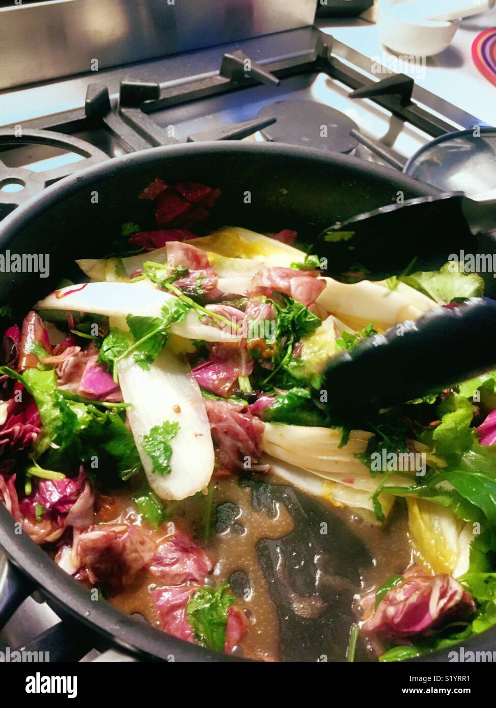 Gourmet salad of radicchio endive and spinach sautéed in a stove top skillet. - Smartphone Captured Stock Image
