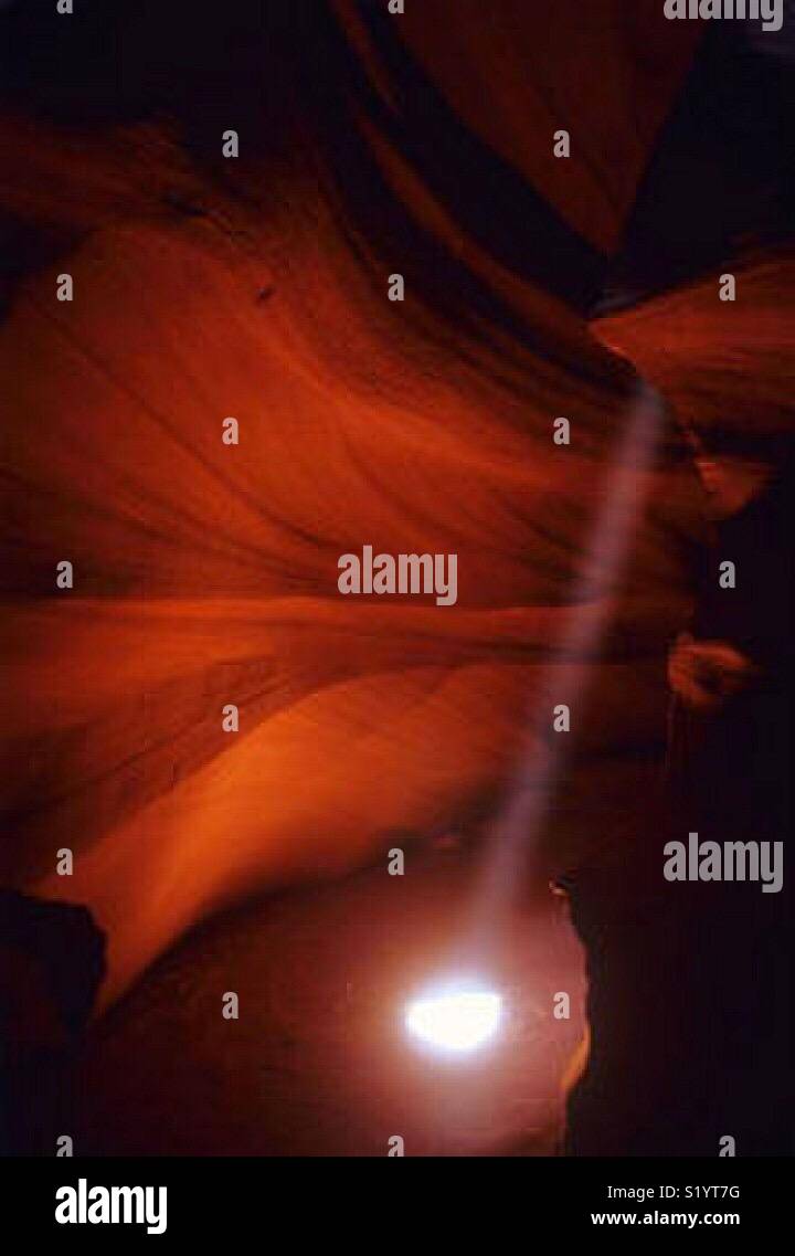 A shaft of light illuminates the corkscrew-like paths of Antelope Canyon. - Smartphone Captured Stock Image