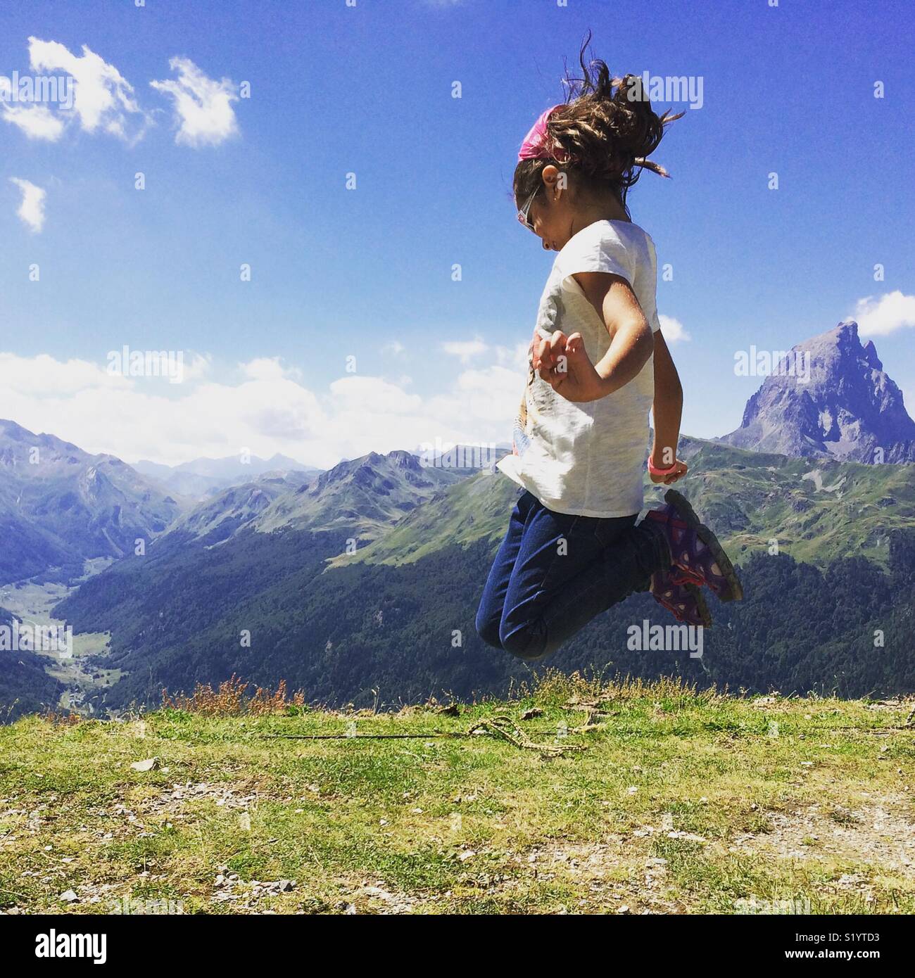 Girl jumping outdoors at the Pyrenees in France Stock Photo