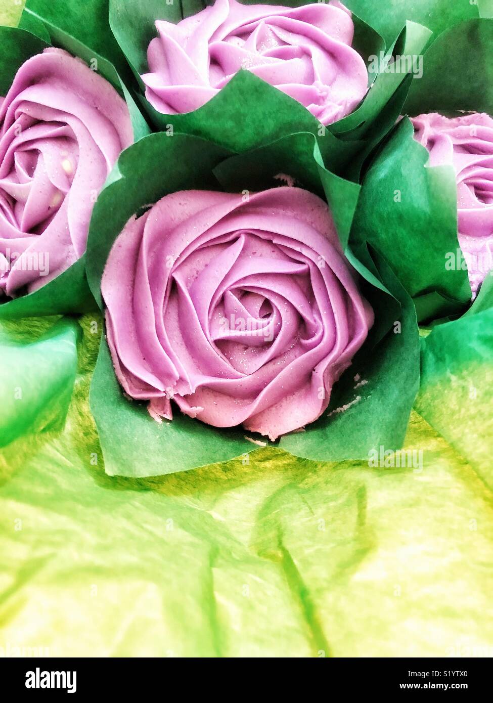 Food art,flowers that are made of piped icing. With a green grease proof paper for leaves. Stock Photo
