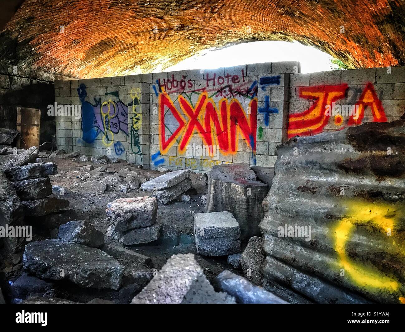 Hobo’s Hotel. Graffiti on a wall in an archway underneath a road - Smartphone Captured Stock Image