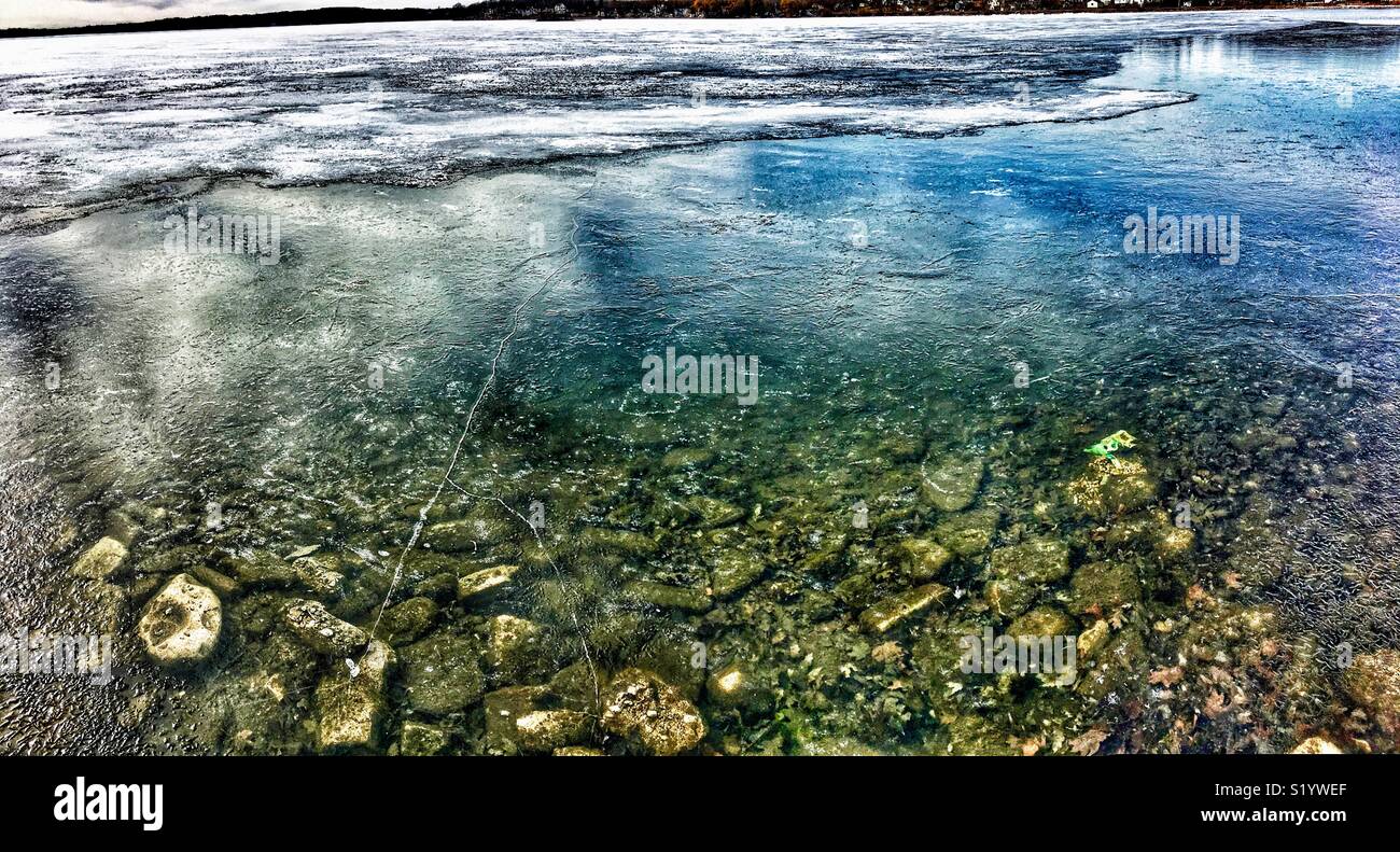 Lake with layer of ice with rocks beneath the surface - Smartphone Captured Stock Image