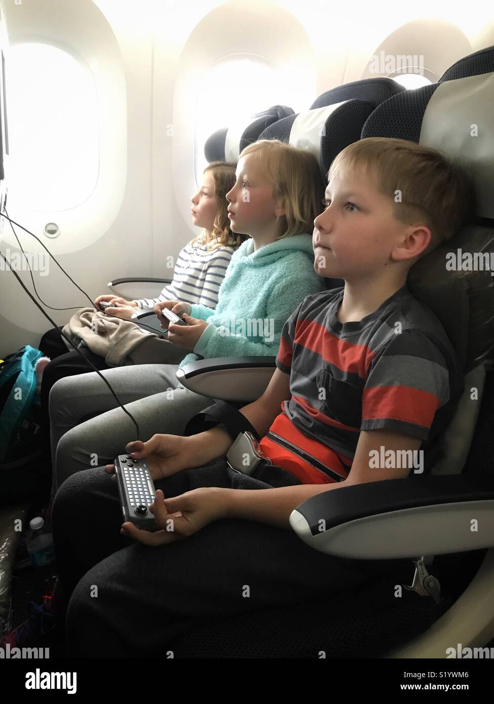 Three Children Play With The In Flight Entertainment System On An Airplane Stock Photo Alamy Three Children Play With The In Flight Entertainment System On An Airplane Stock Photo Alamy